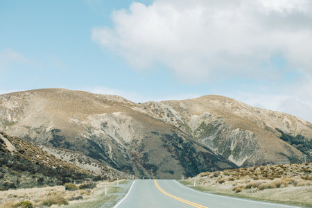Scenic mountain road in serene countryside landscape for adventure travel and explorationの写真素材