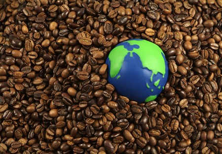 International coffee beans: green and blue globe surrounded by coffee beansの写真素材