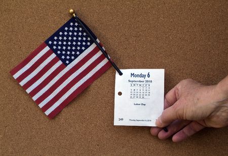 Hand of Person holding American Flag and Labor day calendar page for Monday September 6, 2010. の写真素材