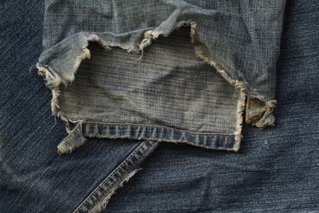 torn and frayed old blue jeansの写真素材