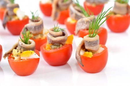 Stuffed cherry tomatoes with anchovies, boiled eggs and green olivesの写真素材