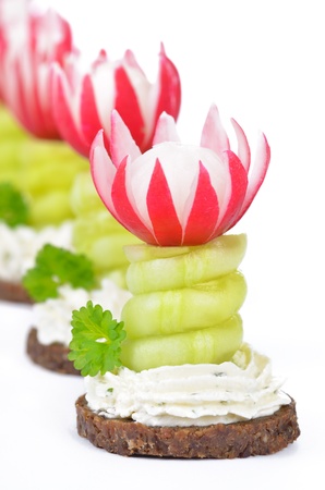 Appetizers with cream cheese, cucumber and radishes on pumpernickelの写真素材
