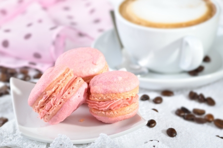 Fine pink macaroons with a cup of cappuccinoの写真素材