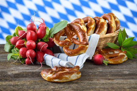 Bavarian pretzels and radishes the Bavarian flag in the backgroundの写真素材