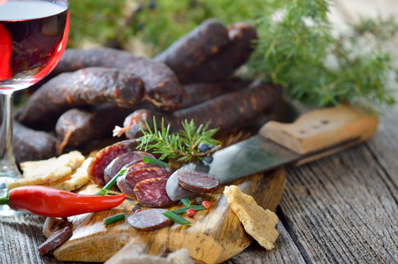 South Tyrolean snack with typical cured sausages and very crispy flatbread, served with a glass of red wineの写真素材
