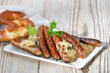 Six peaceful Bavarian sausages from Nuremberg served with Sauerkraut and a pretzelの写真素材
