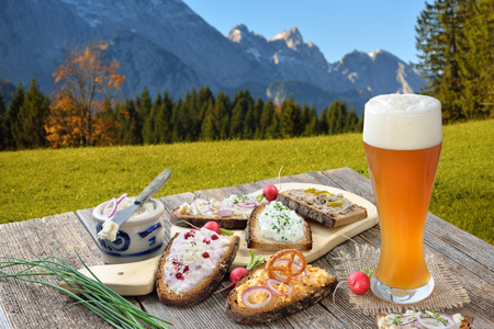 Hearty snack on farmhouse bread served with a fresh yeast on a wooden table in the Bavarian Alpsの写真素材