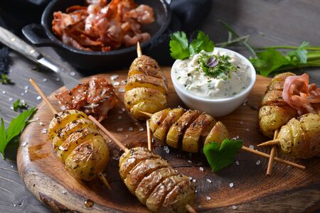 Curd on small skewers with olive oil and served with herb curd and fried bacon strips