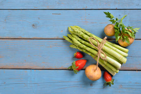 Fresh Bavarian green asparagus from Schrobenhausen on shabby turquoise colored boards with copy spaceの写真素材