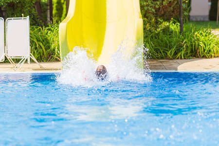 children jump, swim and play in the pool on a beautiful sunny summer day.  fun for kids on sunny summer days.の写真素材