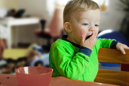 Yawning boy. Toys in  background. Child concept.の写真素材