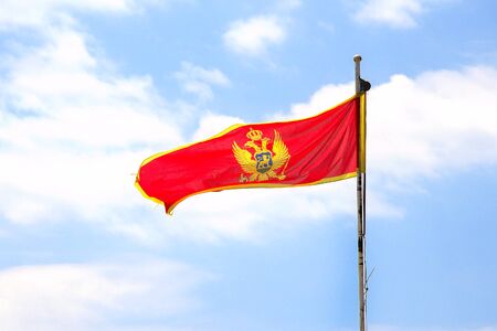 Flag of Montenegro on blue sky background.の写真素材