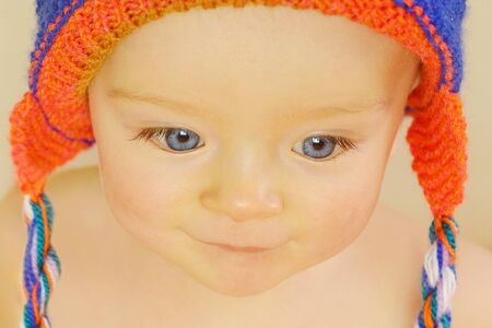 Cute baby with expressive eyes in knitted hat which his grandmother made.の写真素材