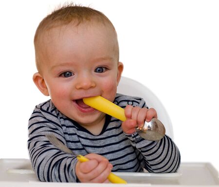 Happy baby boy is prepared to eat lunch with fork and spoon. Child concept. Isolated on white backround.の写真素材