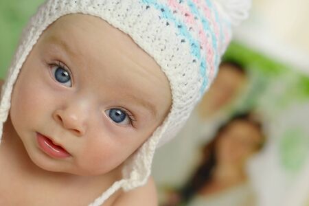 Cute baby and wedding picture with bright and groom in the background.の写真素材