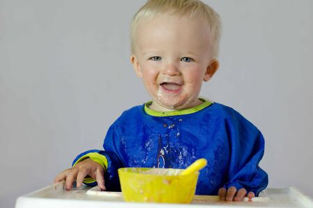 Cute baby in laundry basket in front of washing machine. Child concept.の写真素材