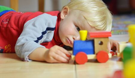 Little Toddler Passionated Playing Woodden Locomotiveの写真素材