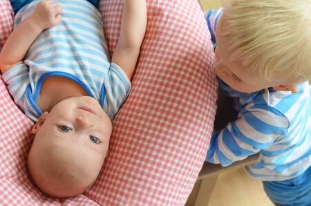Little boy looking at his newborn brother. Child love concept.の写真素材
