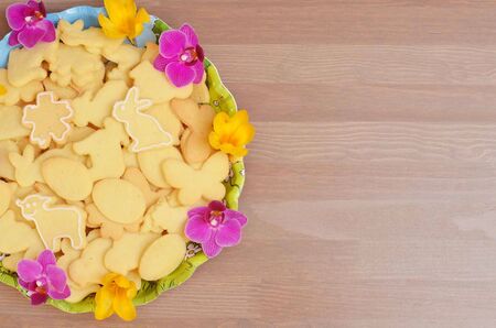 Animal cookies with colorful blossoms in a bowl ona  wooden table.の写真素材