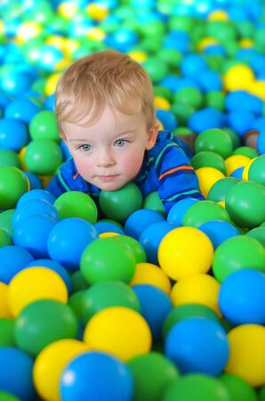 Little boy playing with ball in playing centreの写真素材