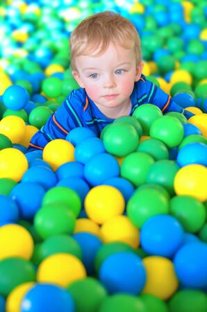 Little boy playing with ball in playing centreの写真素材
