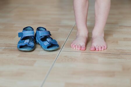 Baby bare feet versus slippers on the floorの写真素材