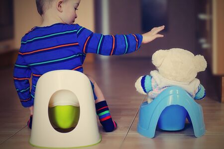Little boy training in potty with his buddy. Retro style.の写真素材