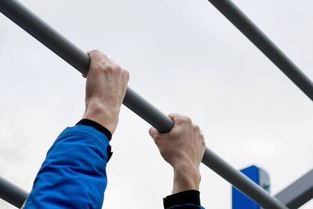 Close-up portrait of man hands training on the gym outsideの写真素材
