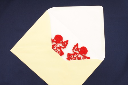 Christmas greetings with envelope and pair red angelsの写真素材