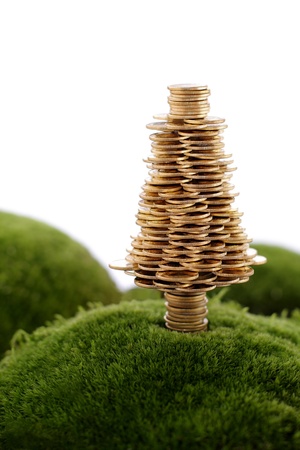 Golden tree made of gold coins on the green hill の写真素材