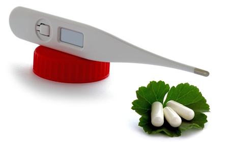 Natural medicine and healthy life, thermometer and drugs on a green leafの写真素材