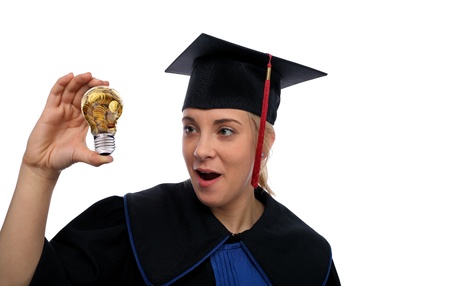 Beautiful girl in the graduation cap and glass bulb with golden coins in handの写真素材