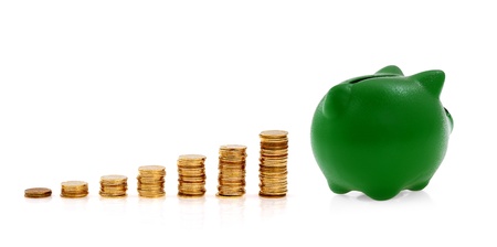 Green piggy bank and golden coins, creative business symbolsの写真素材