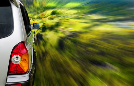 Silver SUV driving fast through the forestの写真素材