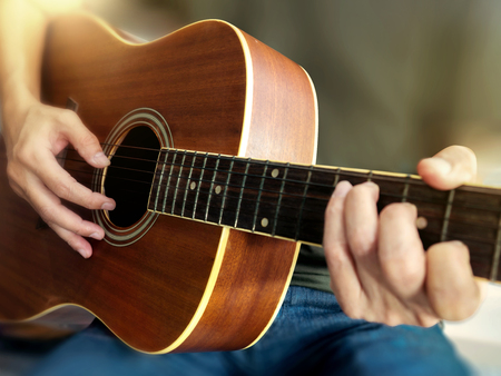 Young musician playing acoustic guitar