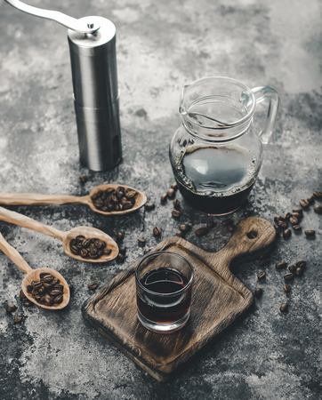 a glass of manual coffee brew on a wooden trayの写真素材