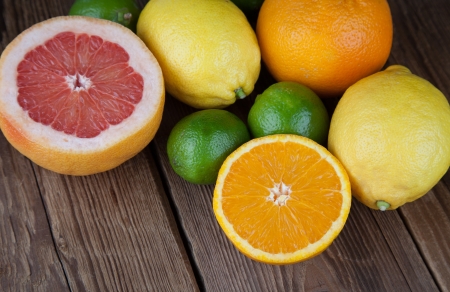 Half grapefruit and half orange on woodの写真素材