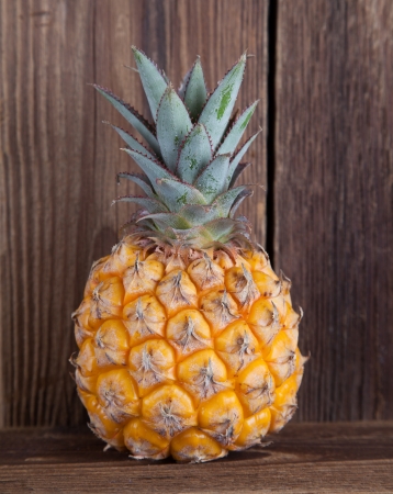 Small pineapple on old woodの写真素材