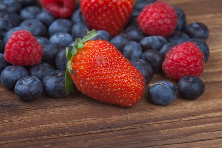 Big Strawberry and other berries on wood の写真素材