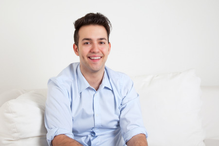 Happy hispanic guy on a sofaの写真素材