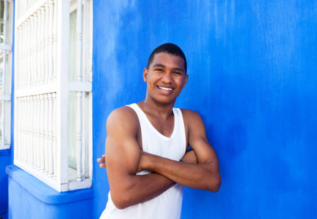 Latin guy with crossed arms in front of a blue wallの写真素材
