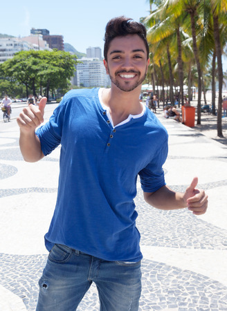 Brazilian guy at Avenida Atlantica at Rio de Janeiro showing thumbの写真素材