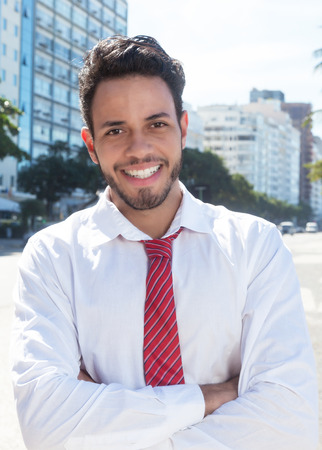 Standing latin businessman in the city with crossed armsの写真素材