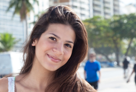 Smiling woman with dark hair in the cityの写真素材
