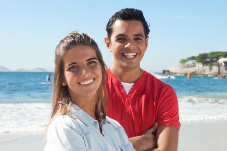 Latin couple at beach looking at cameraの写真素材
