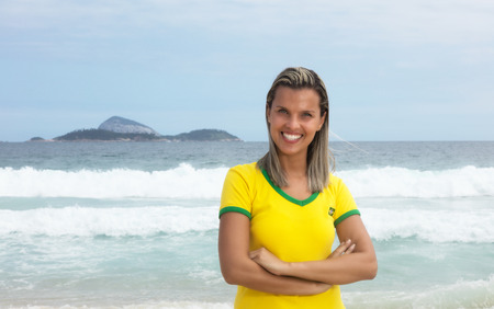 Blonde brazilian sports fan with crossed arms at beachの写真素材