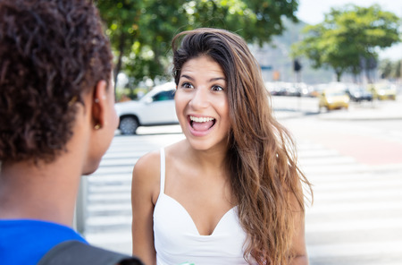 Happy caucasian girl speaking with african american girlfriendの写真素材