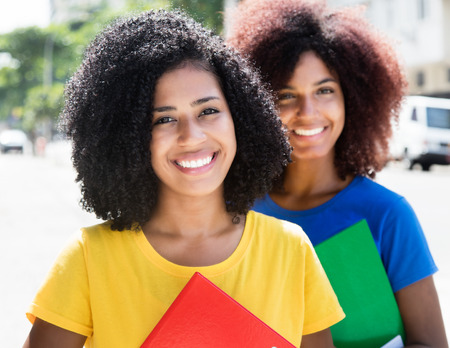 Two latin female students looking at cameraの写真素材