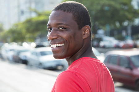 African american guy in a red shirt looking back