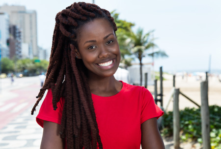 Laughing african woman with dreadlocks in the city
